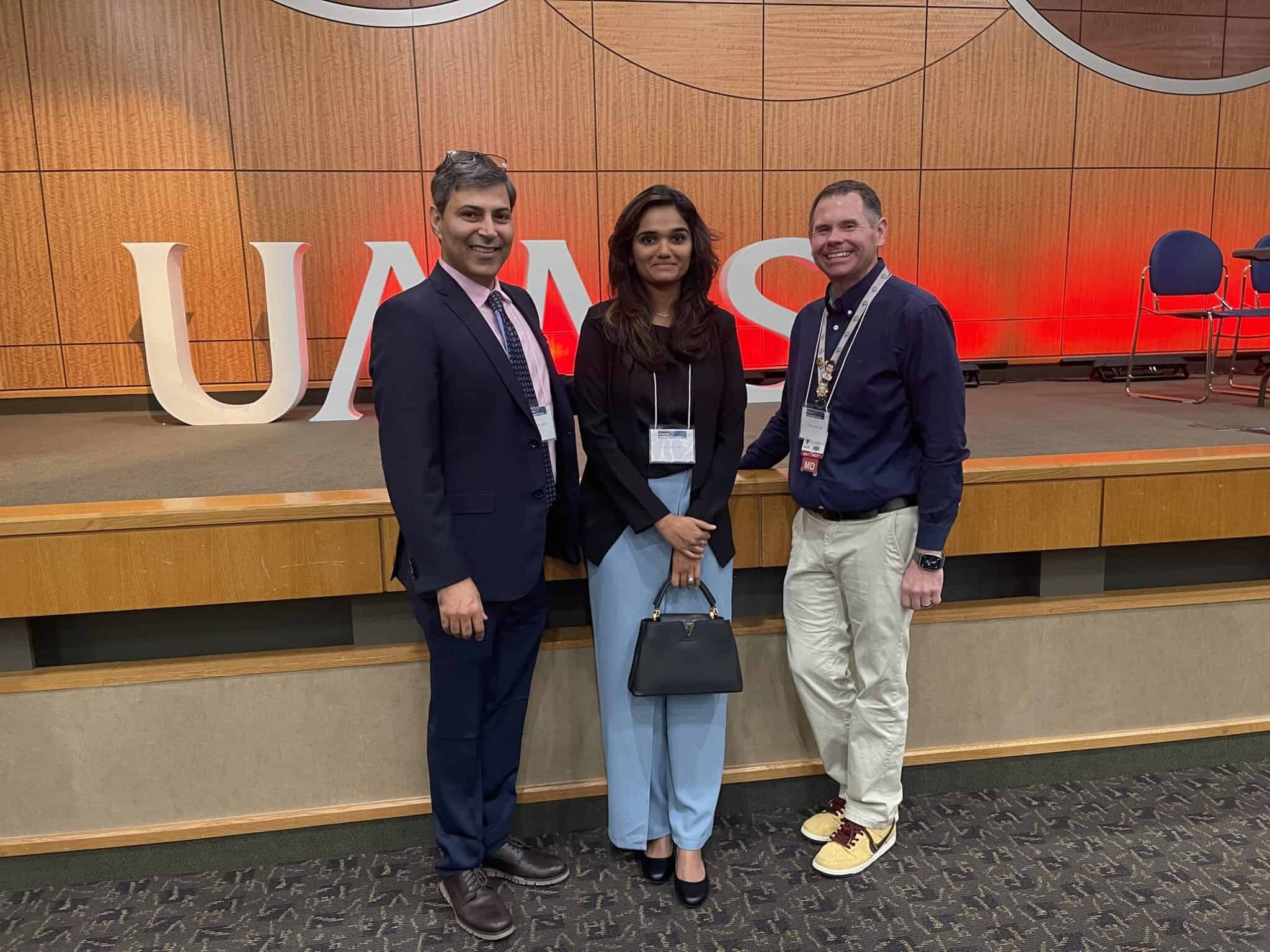 Three attendees standing together in front of the stage at the 2025 ANS Annual Meeting.